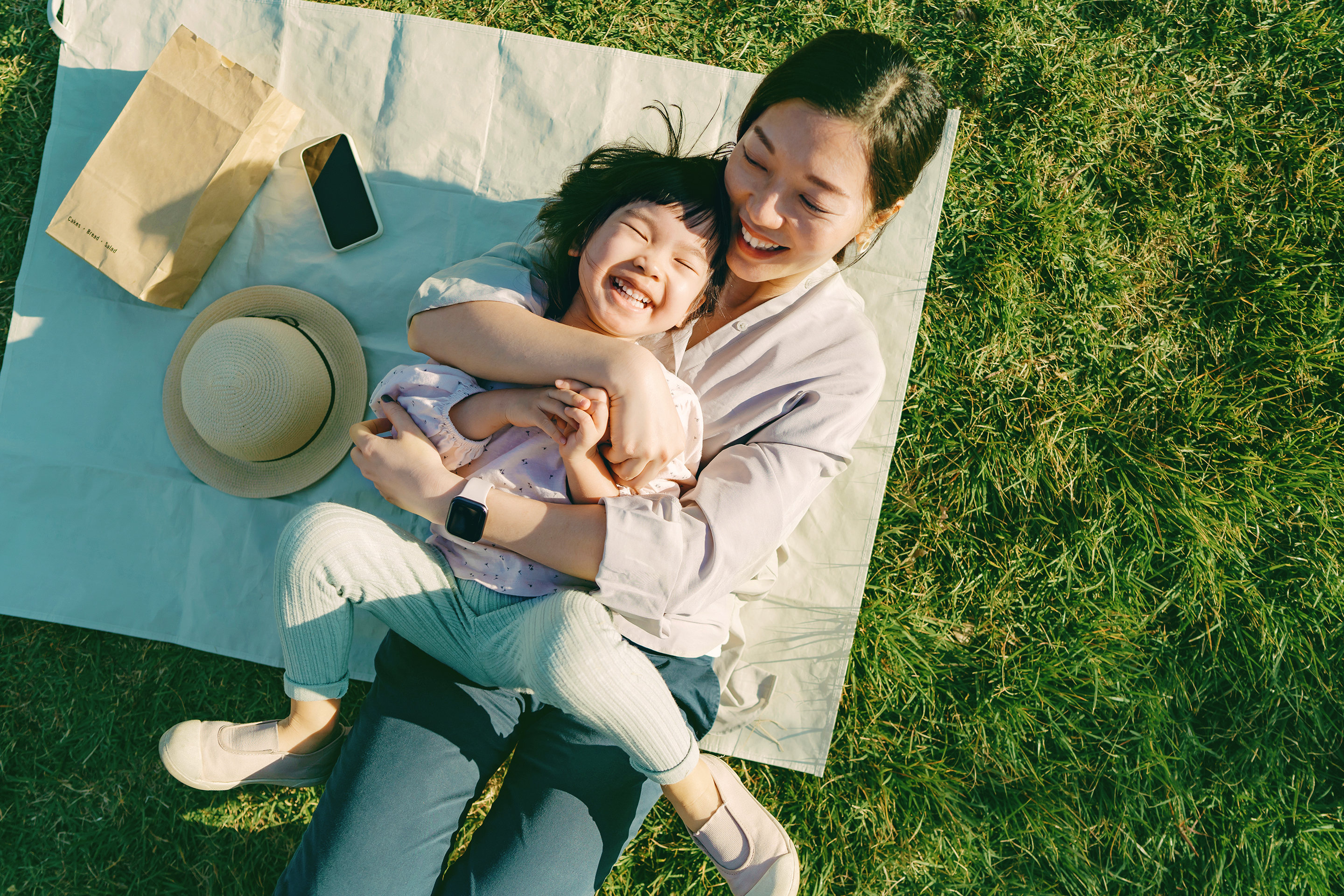 Mother holding her young daughter and laughing.