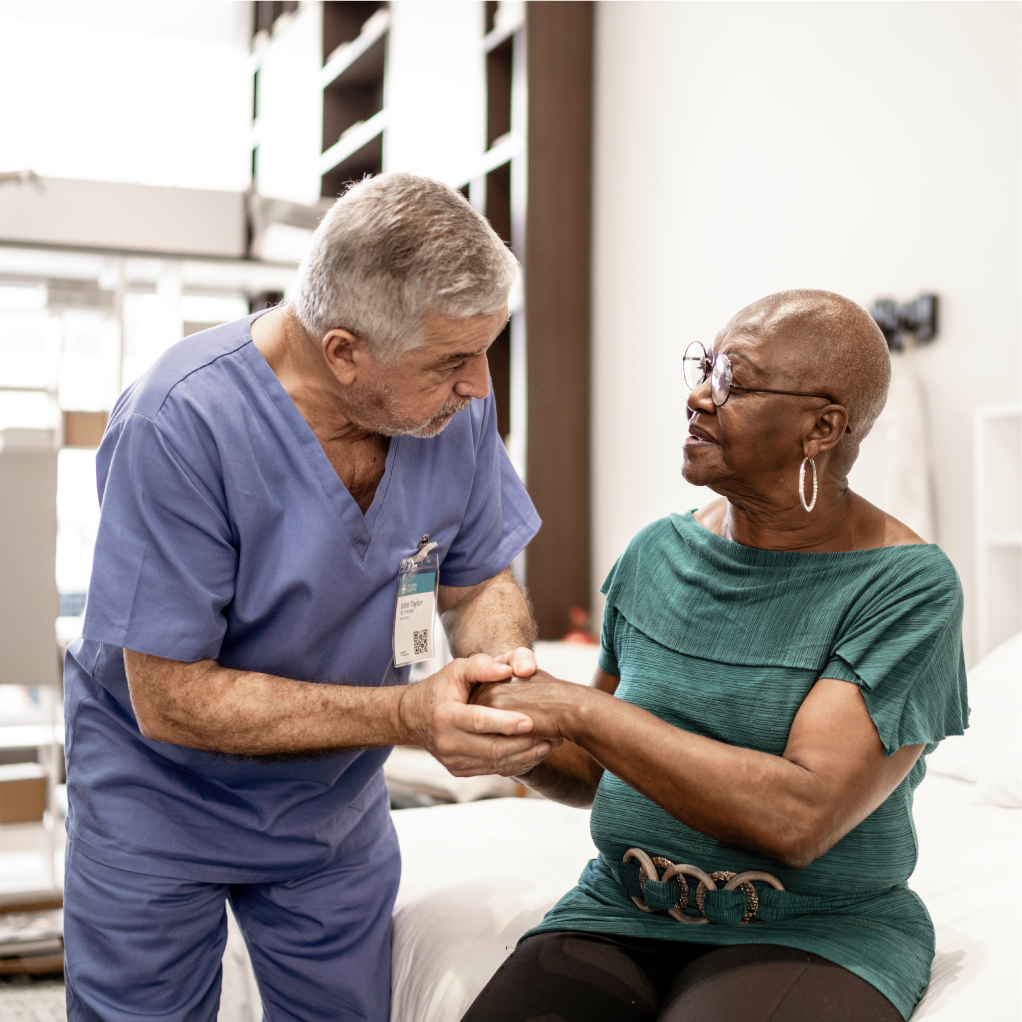 Nurse comforting his patient by holding her hand.