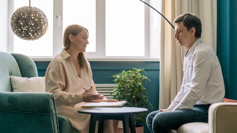 A patient meeting with a behavioral therapist in a cozy, well-lit room
