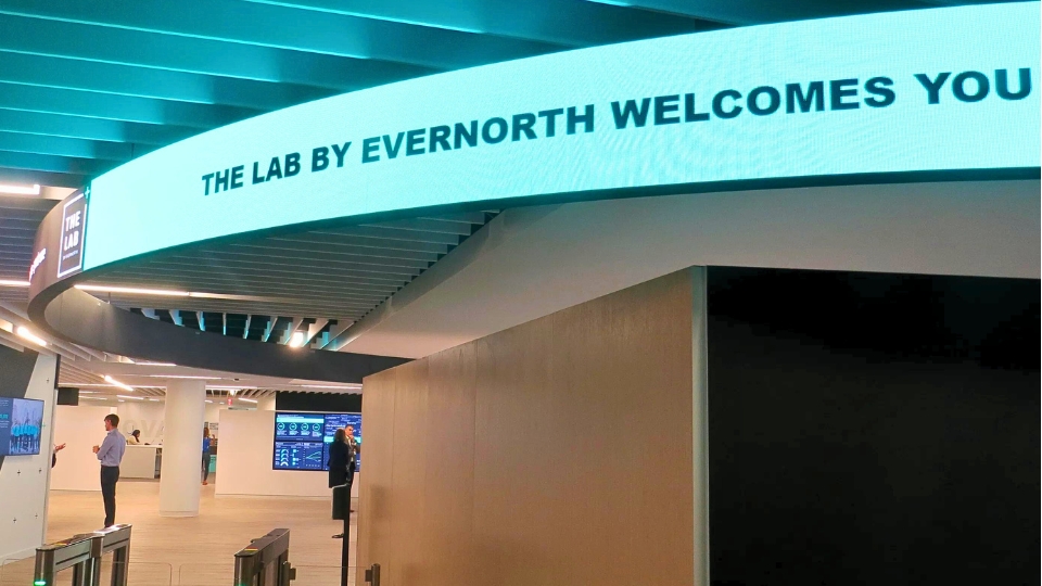 Modern curved wall with illuminated sign reading The Lab by Evernorth Welcomes You