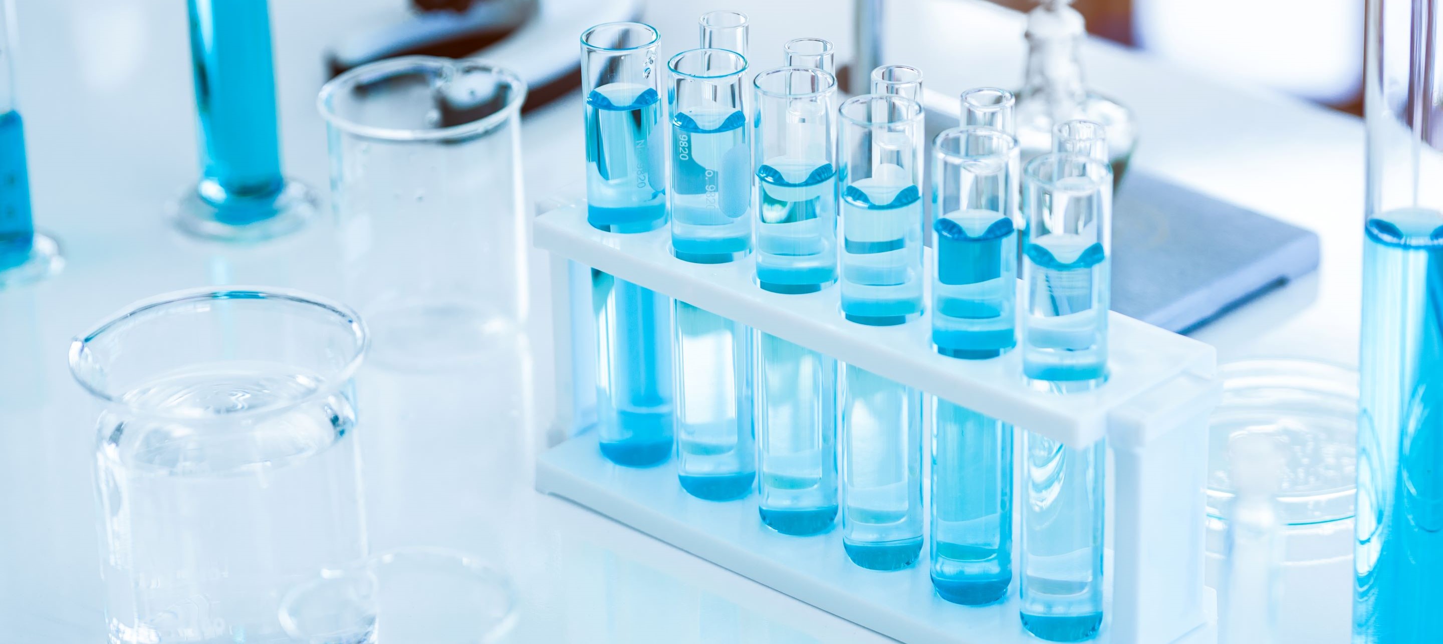 Laboratory scene with test tubes and beakers filled with liquid on a white rack