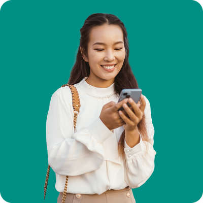 Smiling woman in white sweater holding smartphone against solid teal background