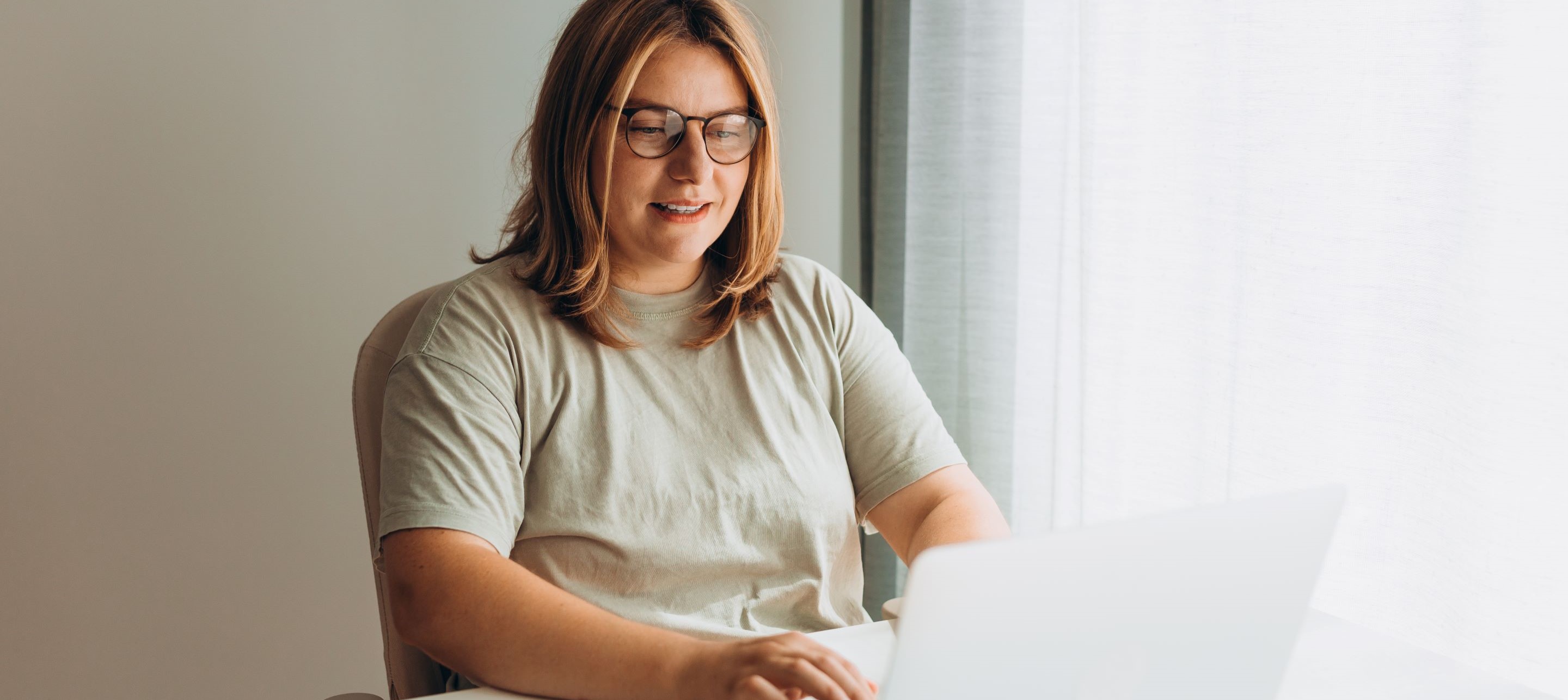 Woman with glasses working on laptop