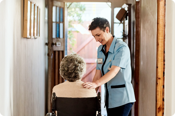 visiting nurse tends to an elderly patient in her home