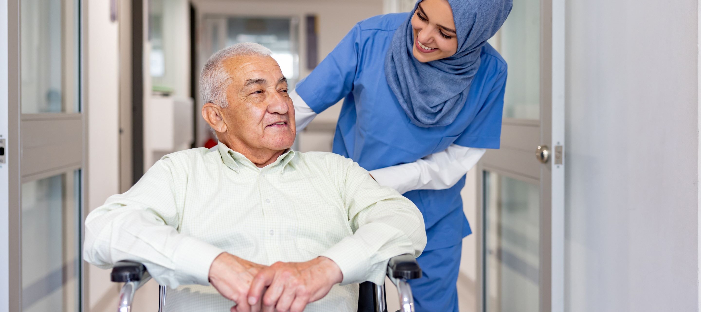 Healthcare working assisting man in wheelchair