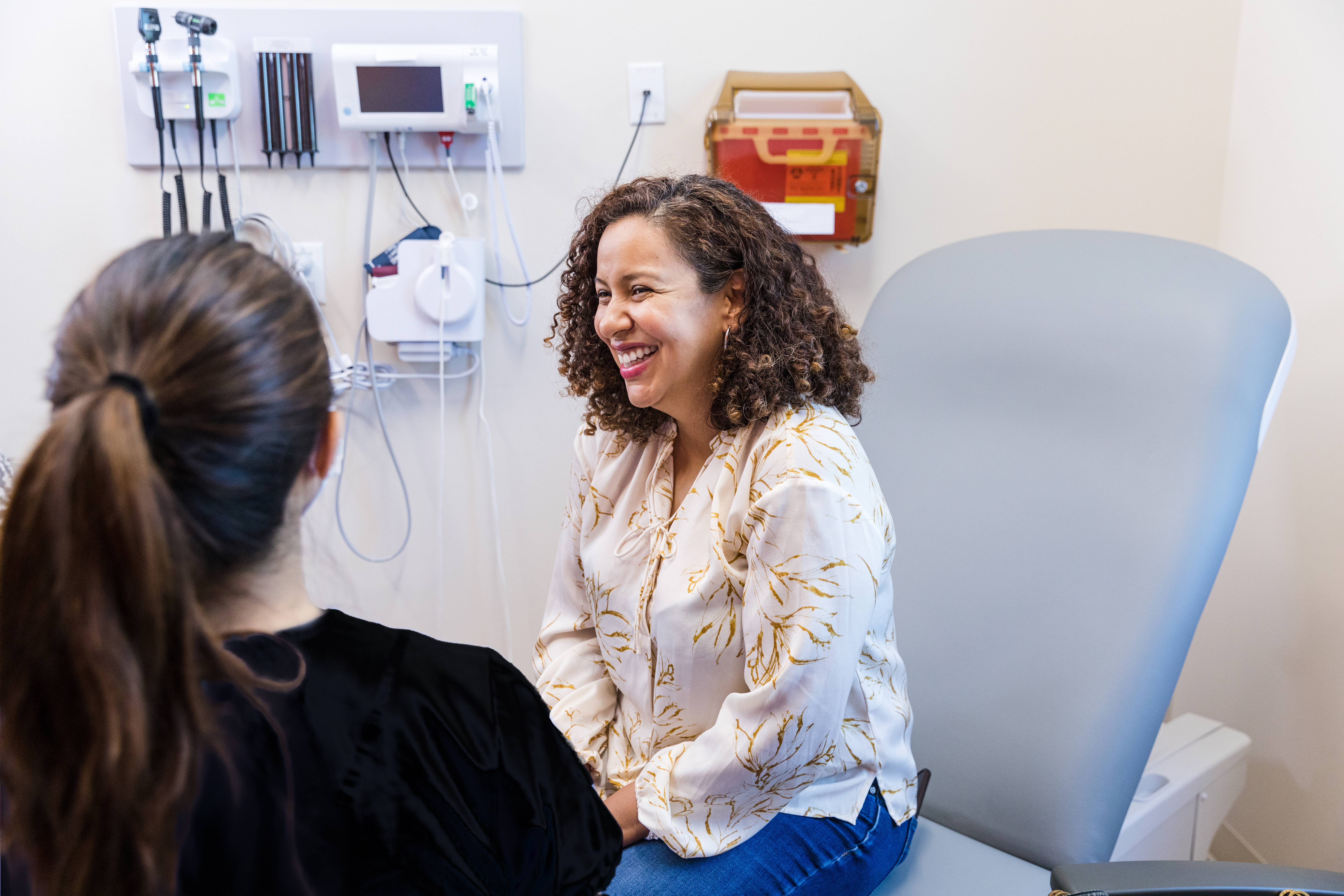 Woman sitting on chair smiling in doctor's office