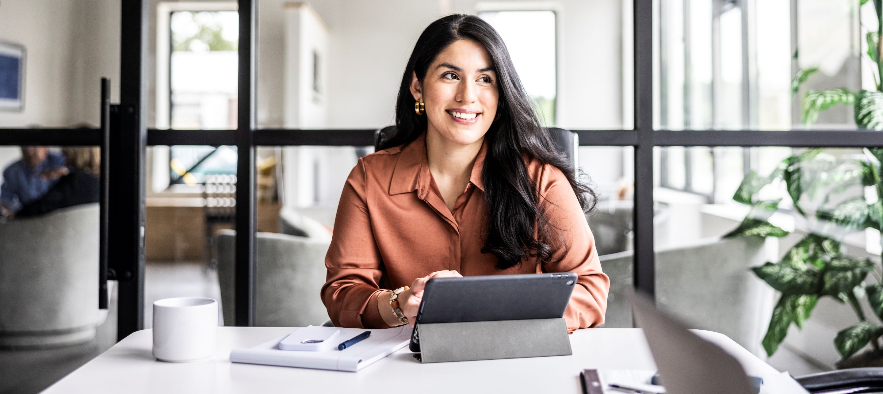 Woman sitting at desk with laptop and pen