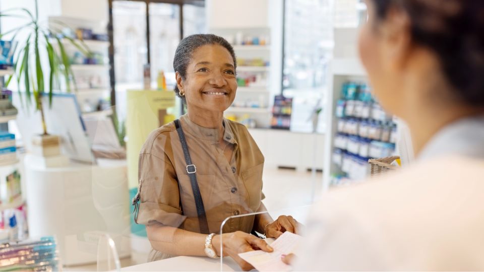 African American woman smiling behind counter.