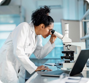 woman looking into microscope