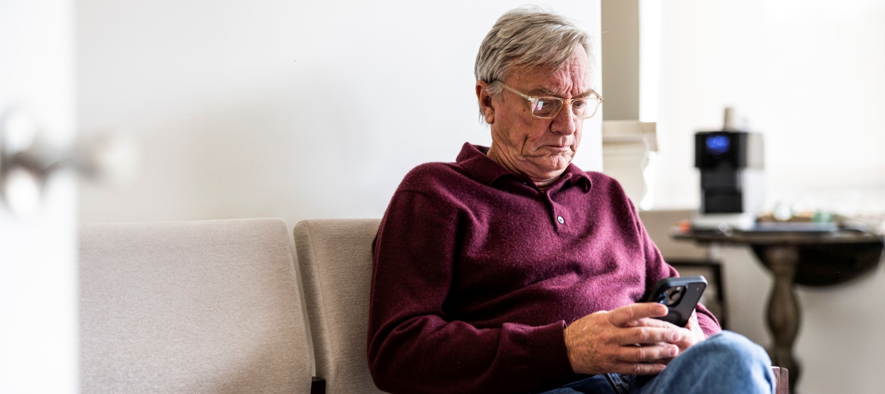 Man sitting on chair, looking at cell phone