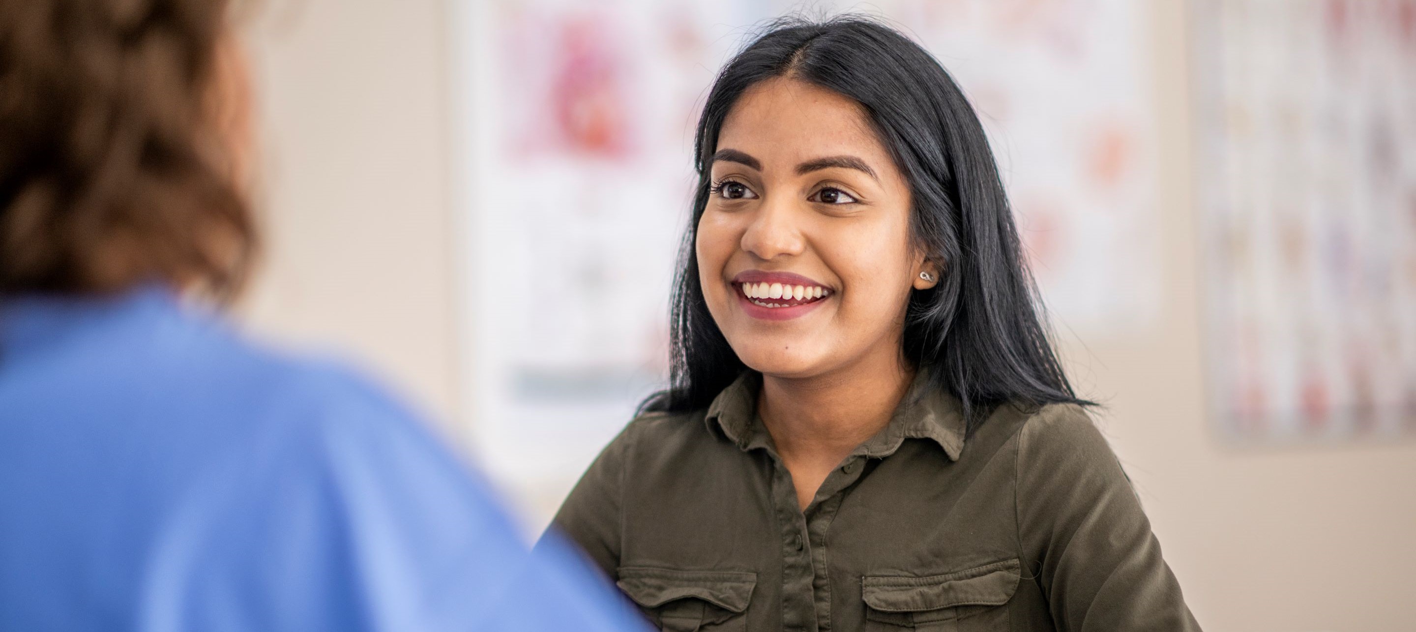 Smiling woman with dark hair and green shirt