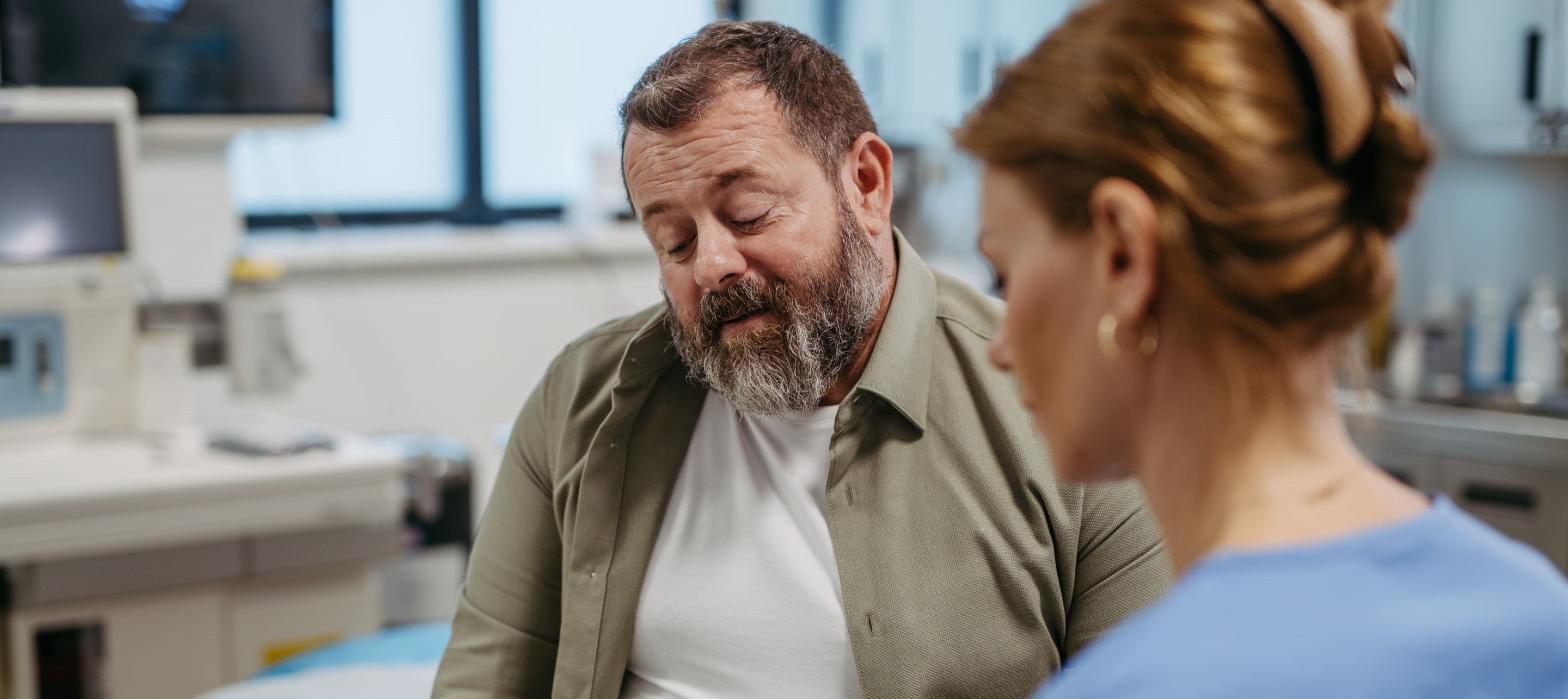 Man wearing brown shirt talking to woman wearing blue shirt