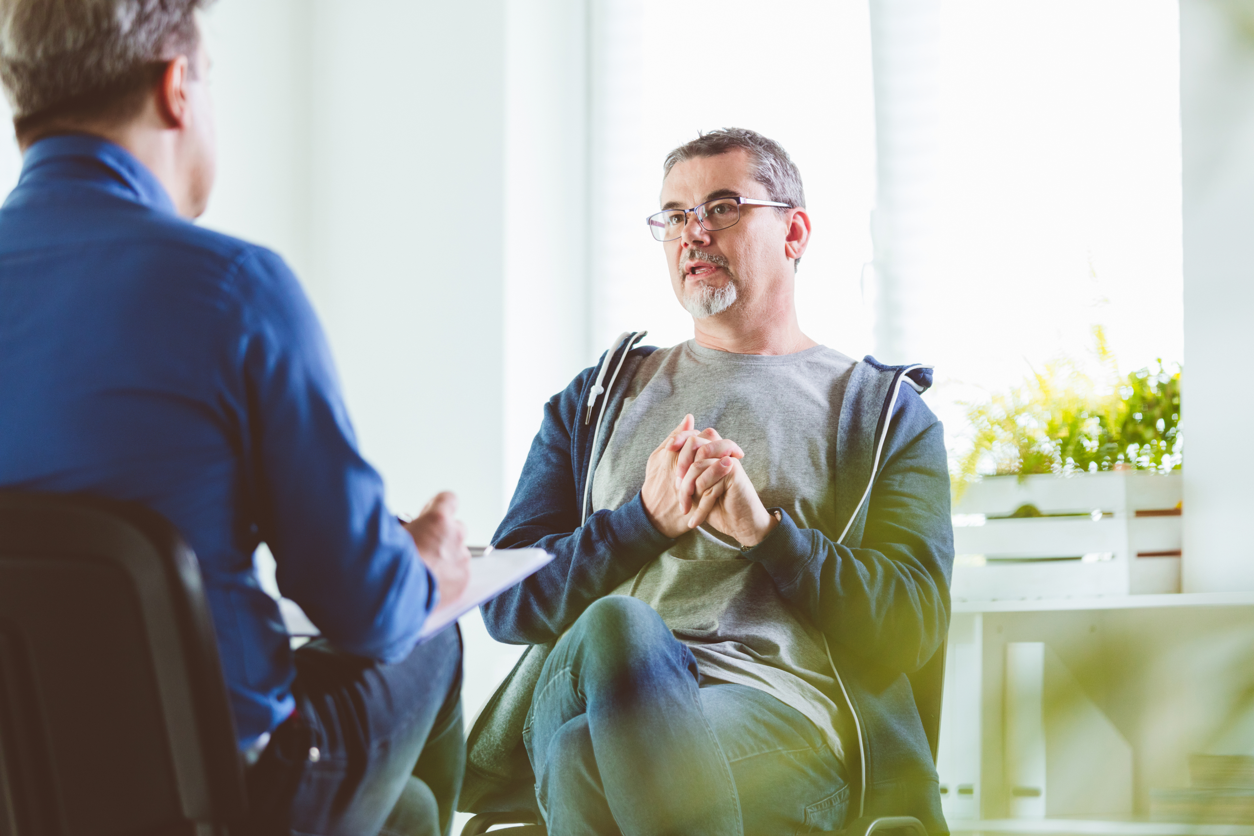 Patient talking to a man in chair