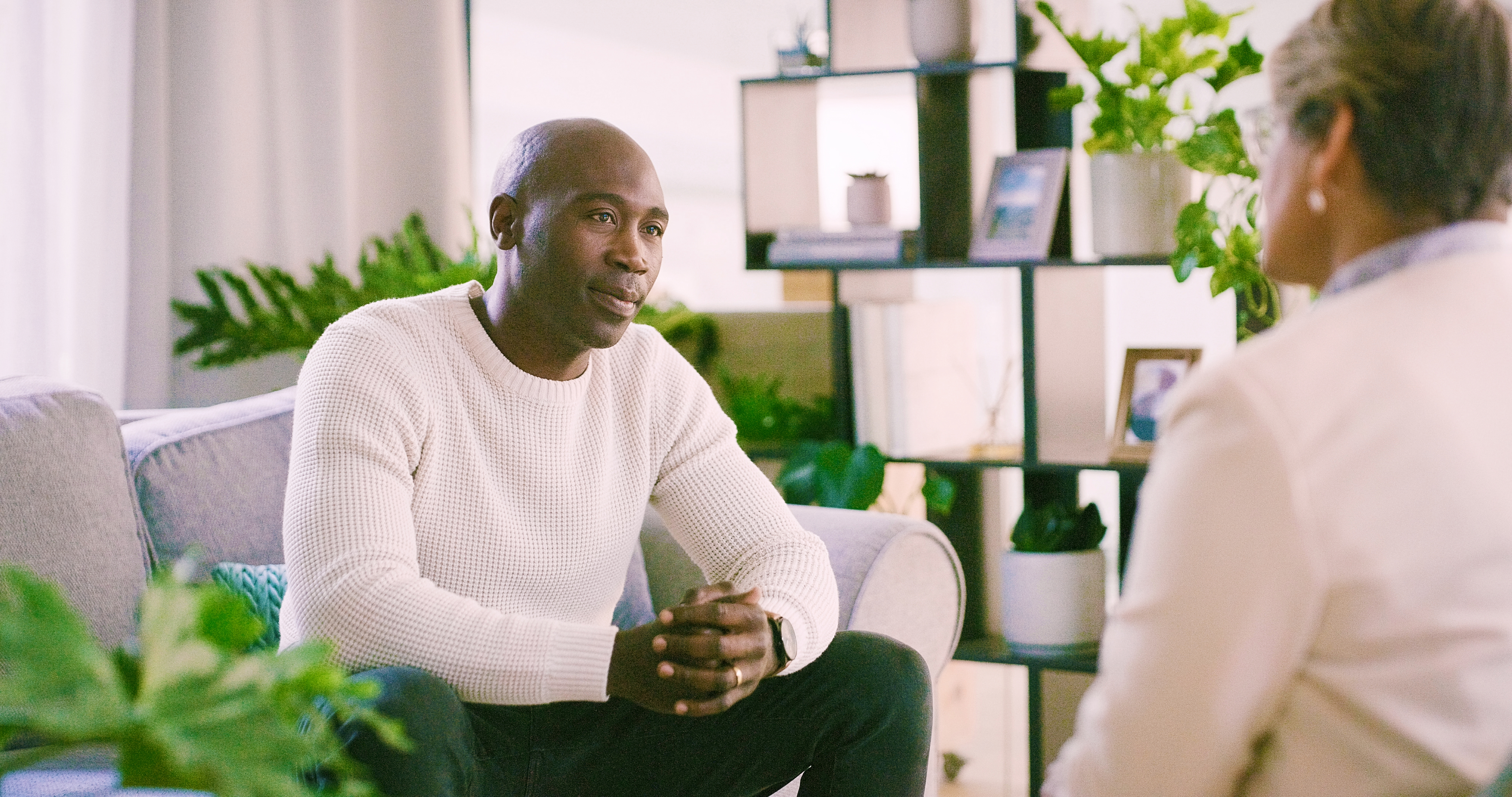man sitting in chair talking to therapist in office