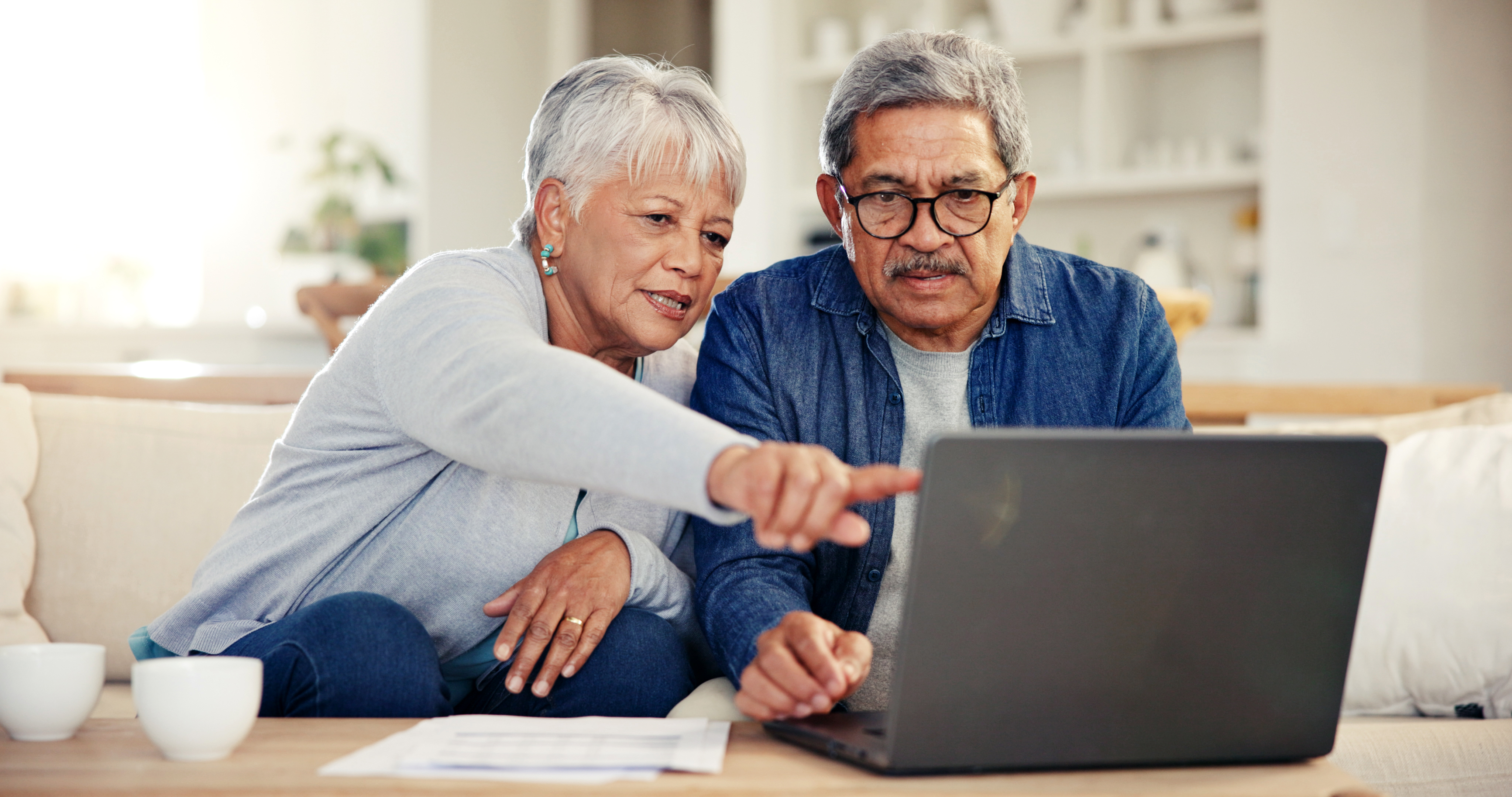 mature couple sitting looking at laptop