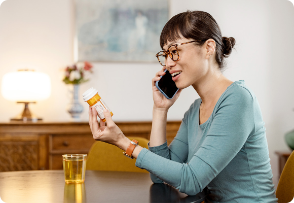 woman holding pills on phone