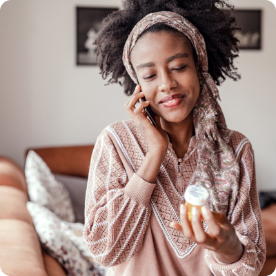 woman on phone with pill bottle