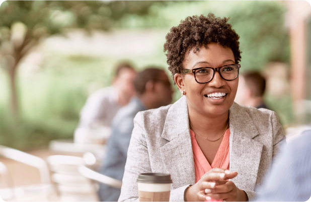 woman with glasses smiling with coffee