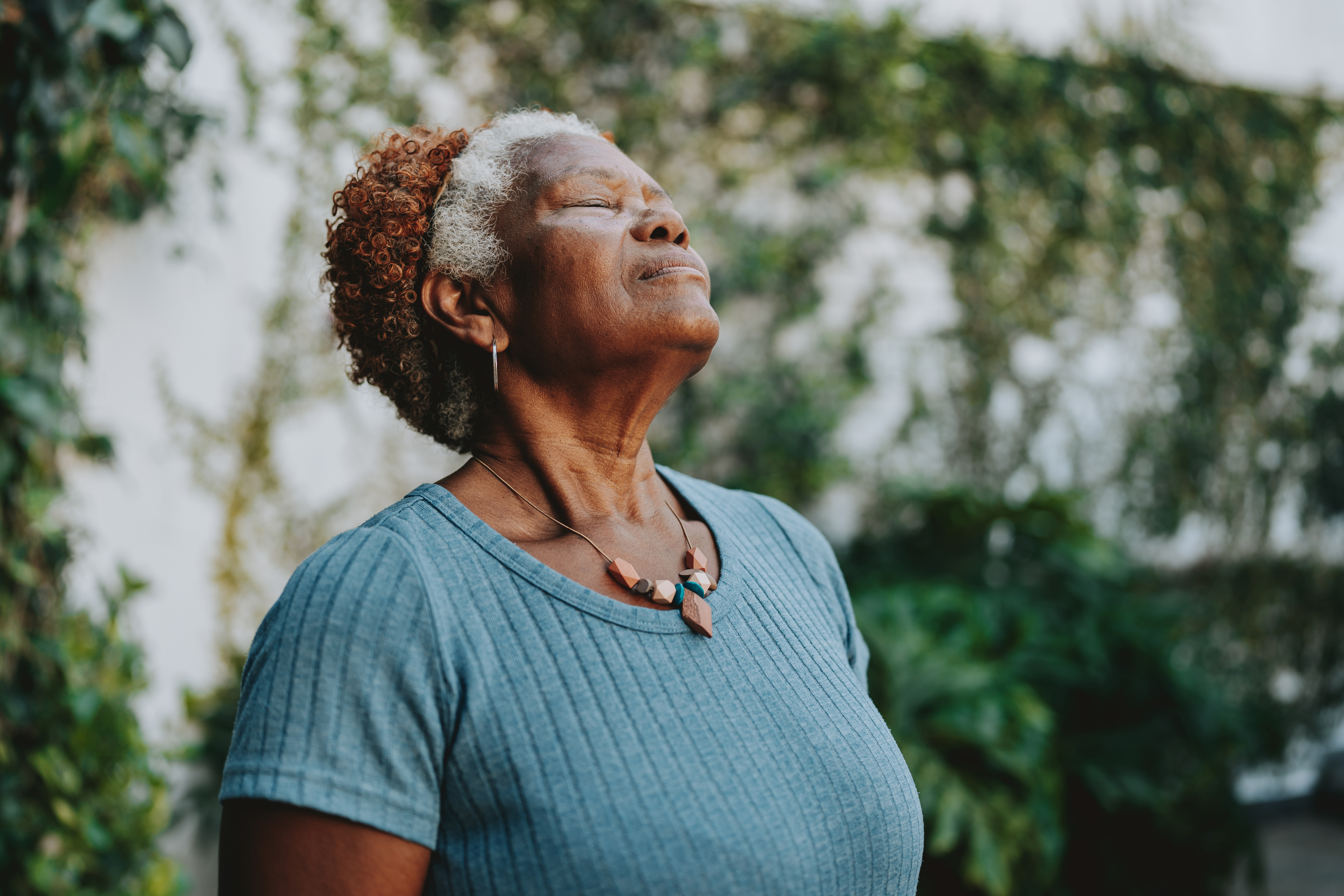 older woman looking upward with eyes closed