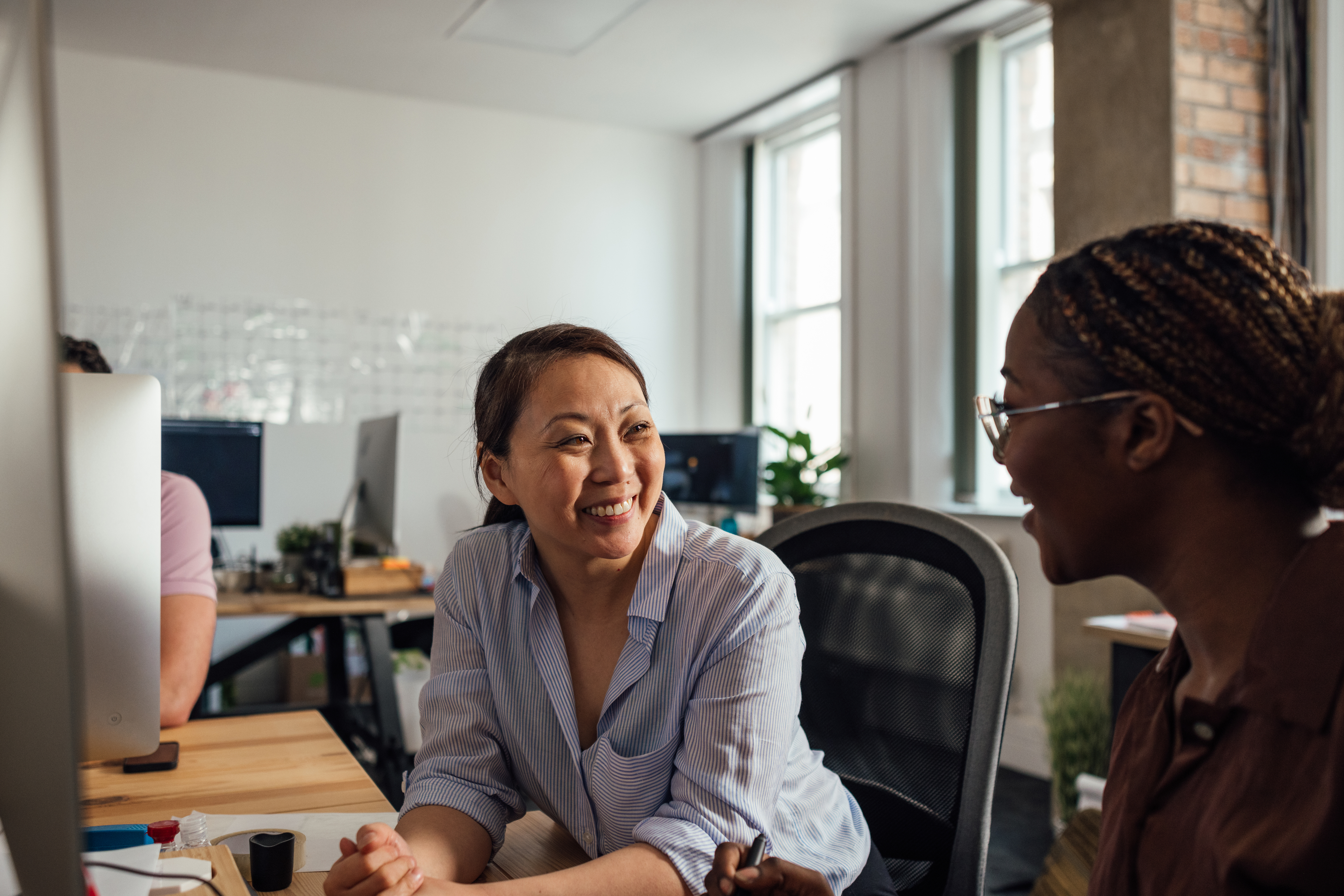 Two women sitting in chairs smiling
