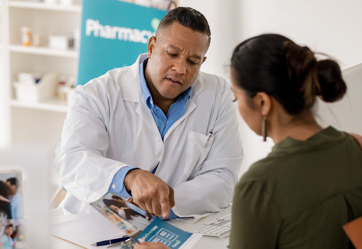 male pharmacist showing woman paper