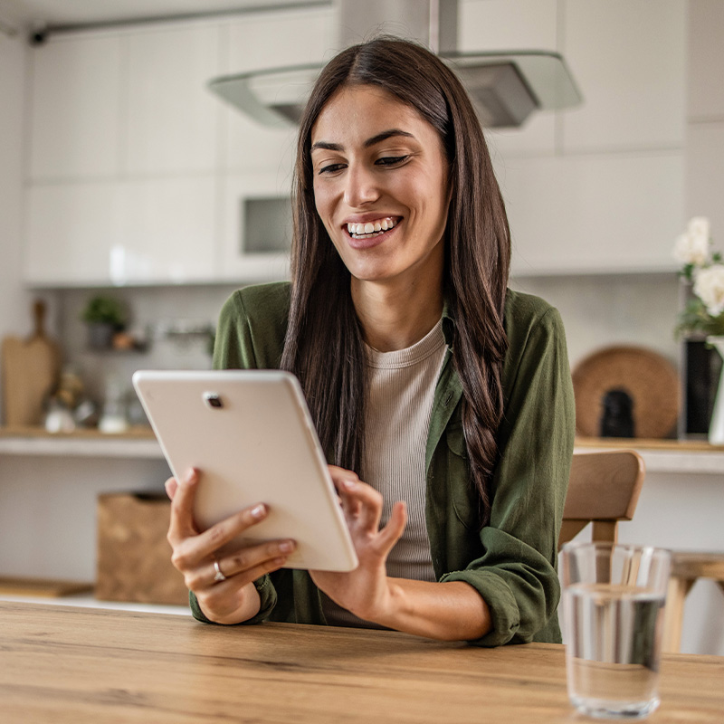 woman on tablet in home smiling