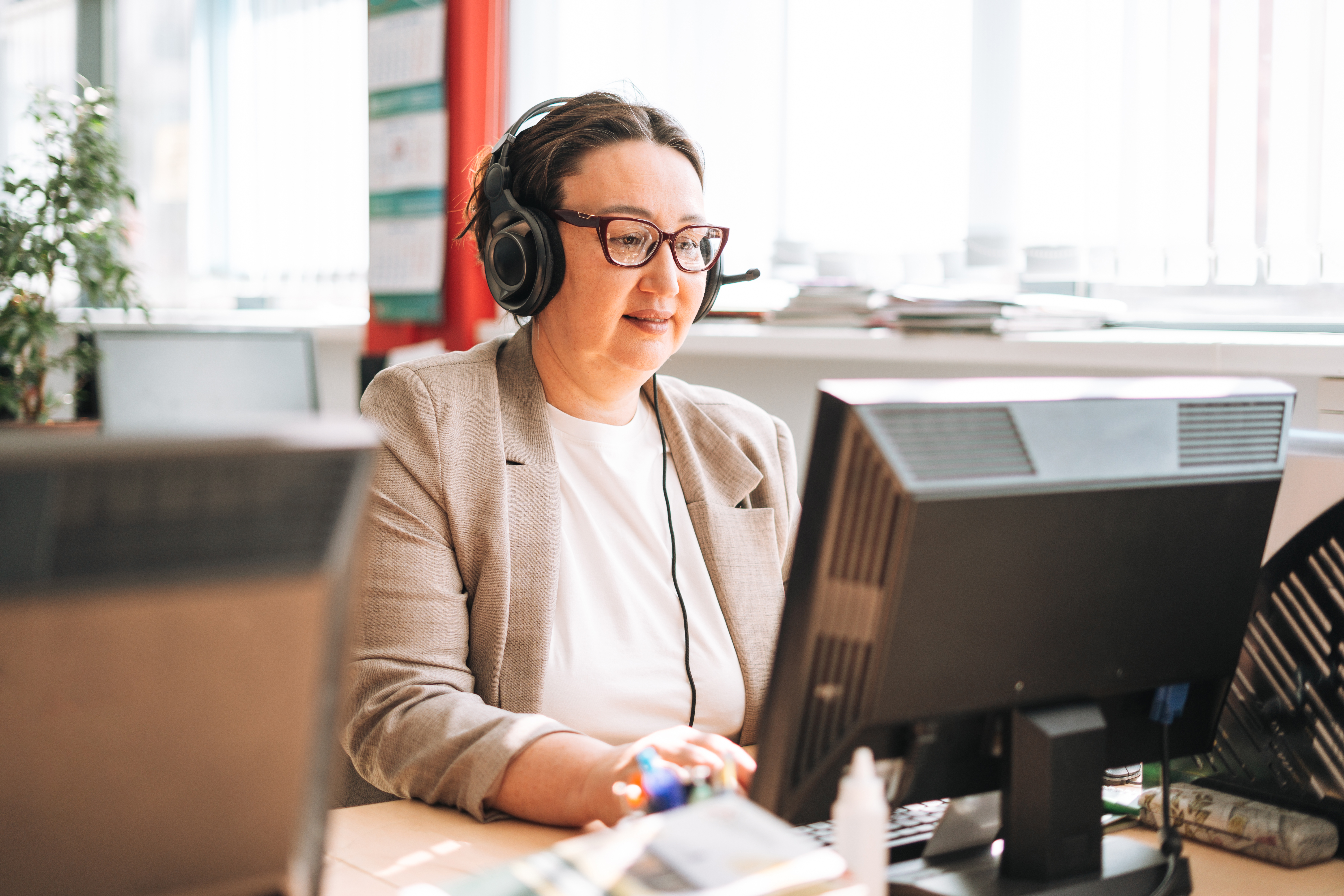 Woman working on laptop and talking on phone