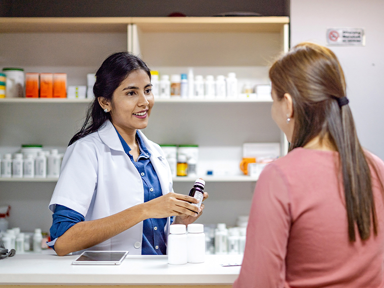 pharmacist with patient and pill bottle