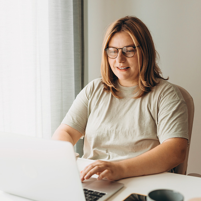 woman with glasses on computer