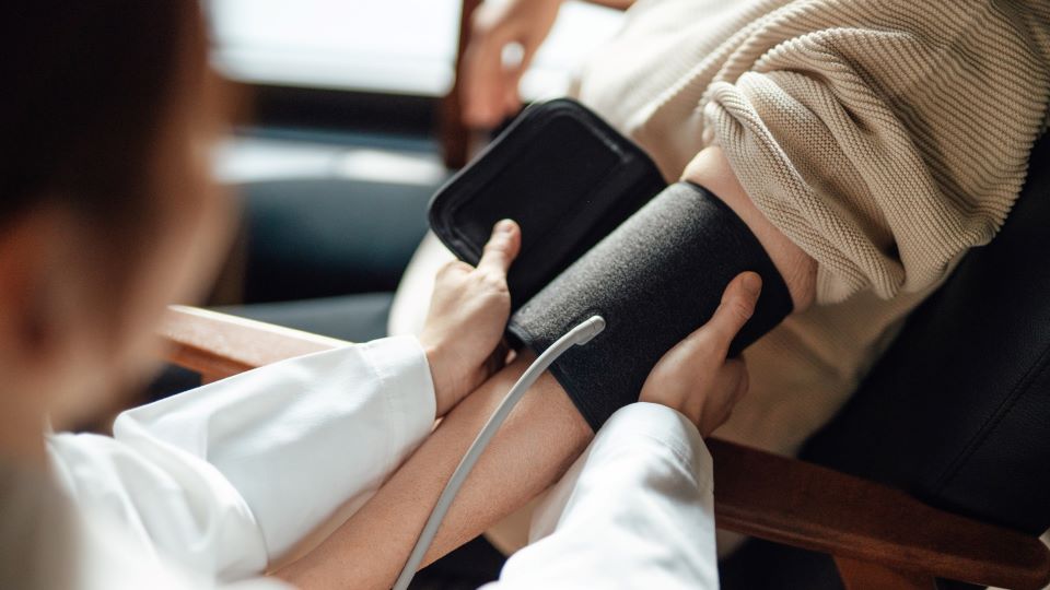 patient receives a blood pressure test on upper arm from a nurse