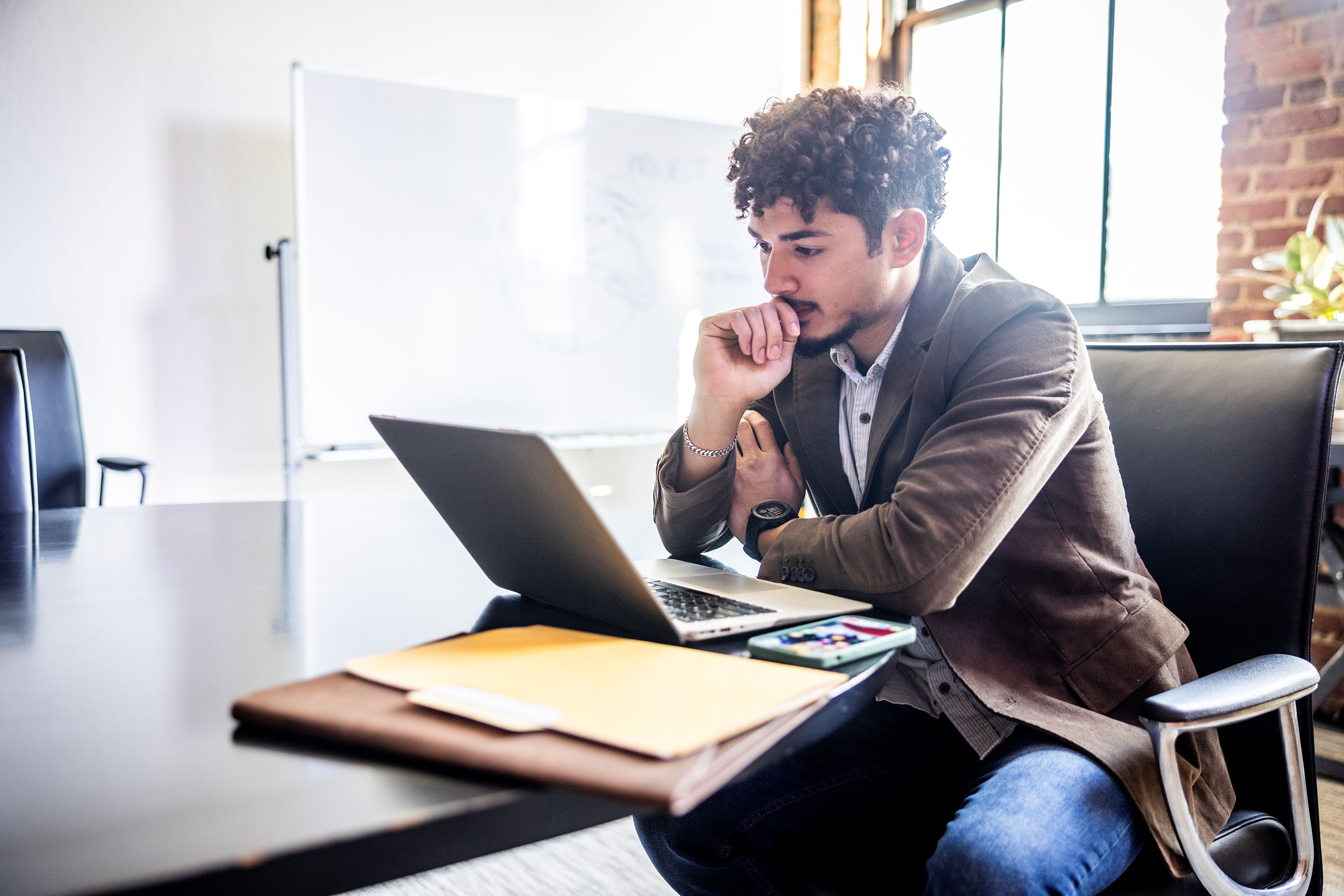 male young employee looking at laptop