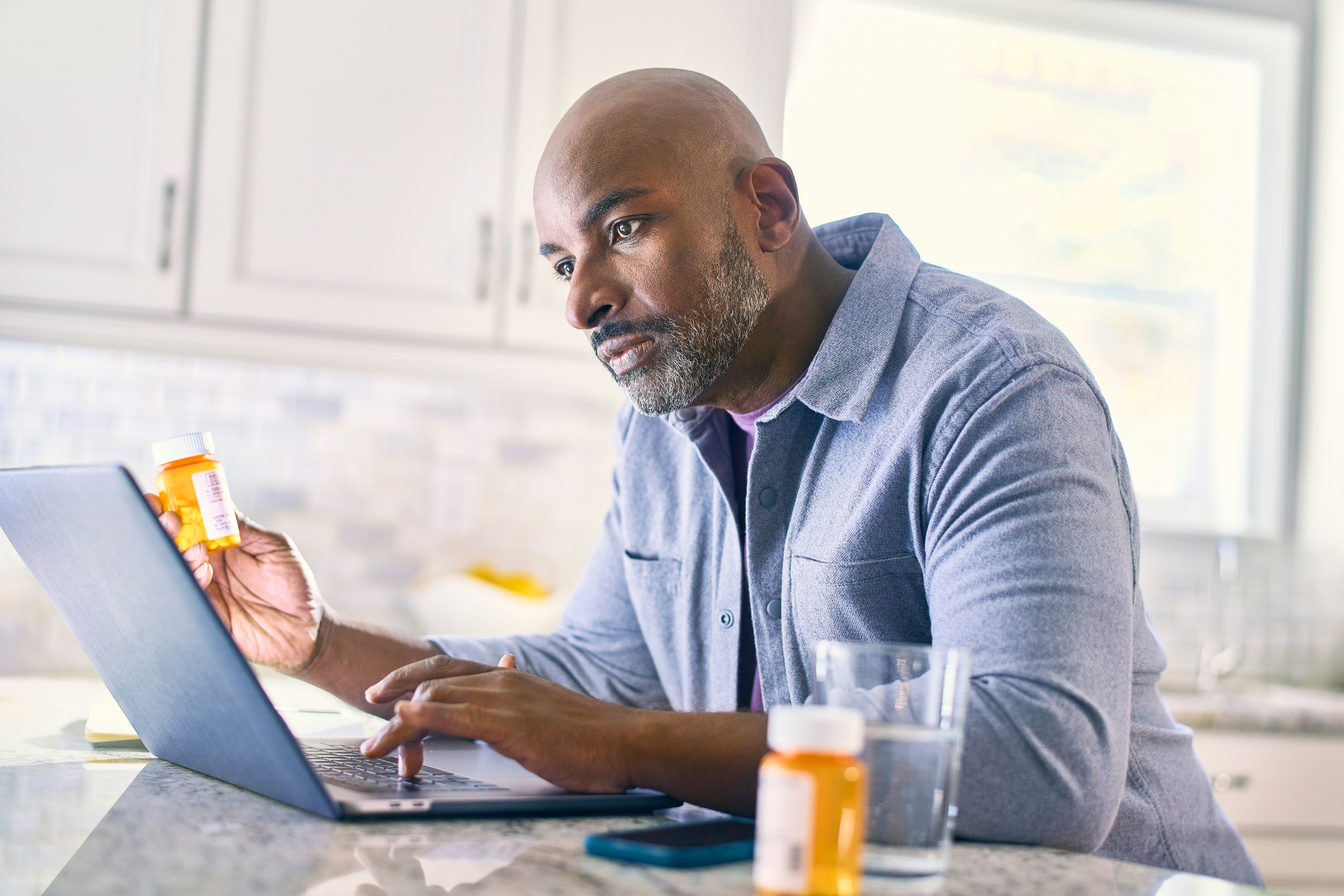 man with pills and laptop