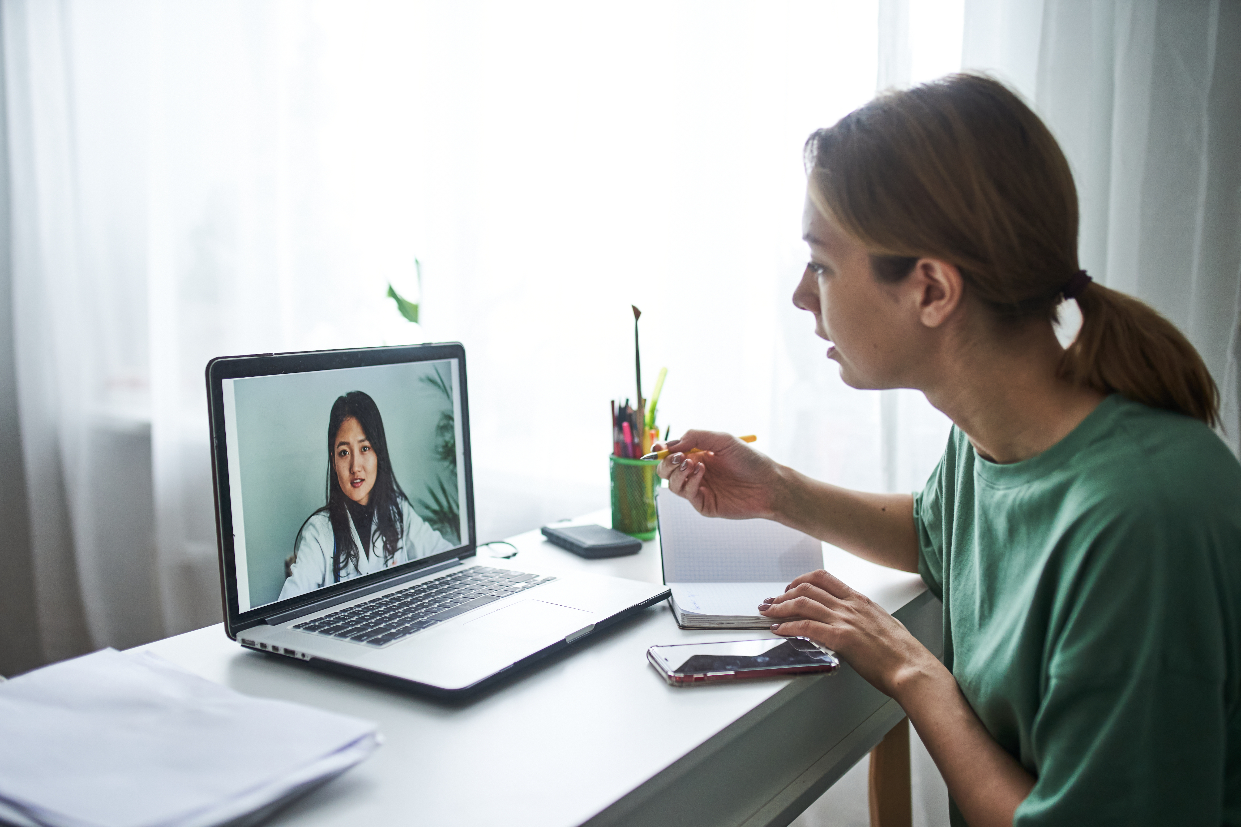 woman on a telemedicine appointment with her doctor on her laptop