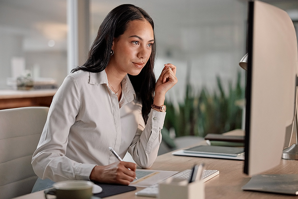 woman at her desk looking at a computer screen