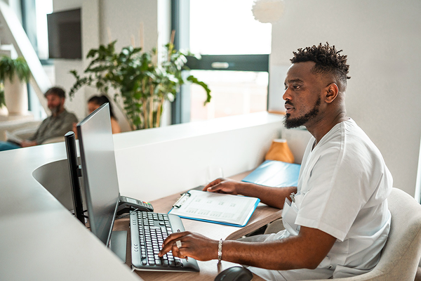 man sitting at his desk on a computer