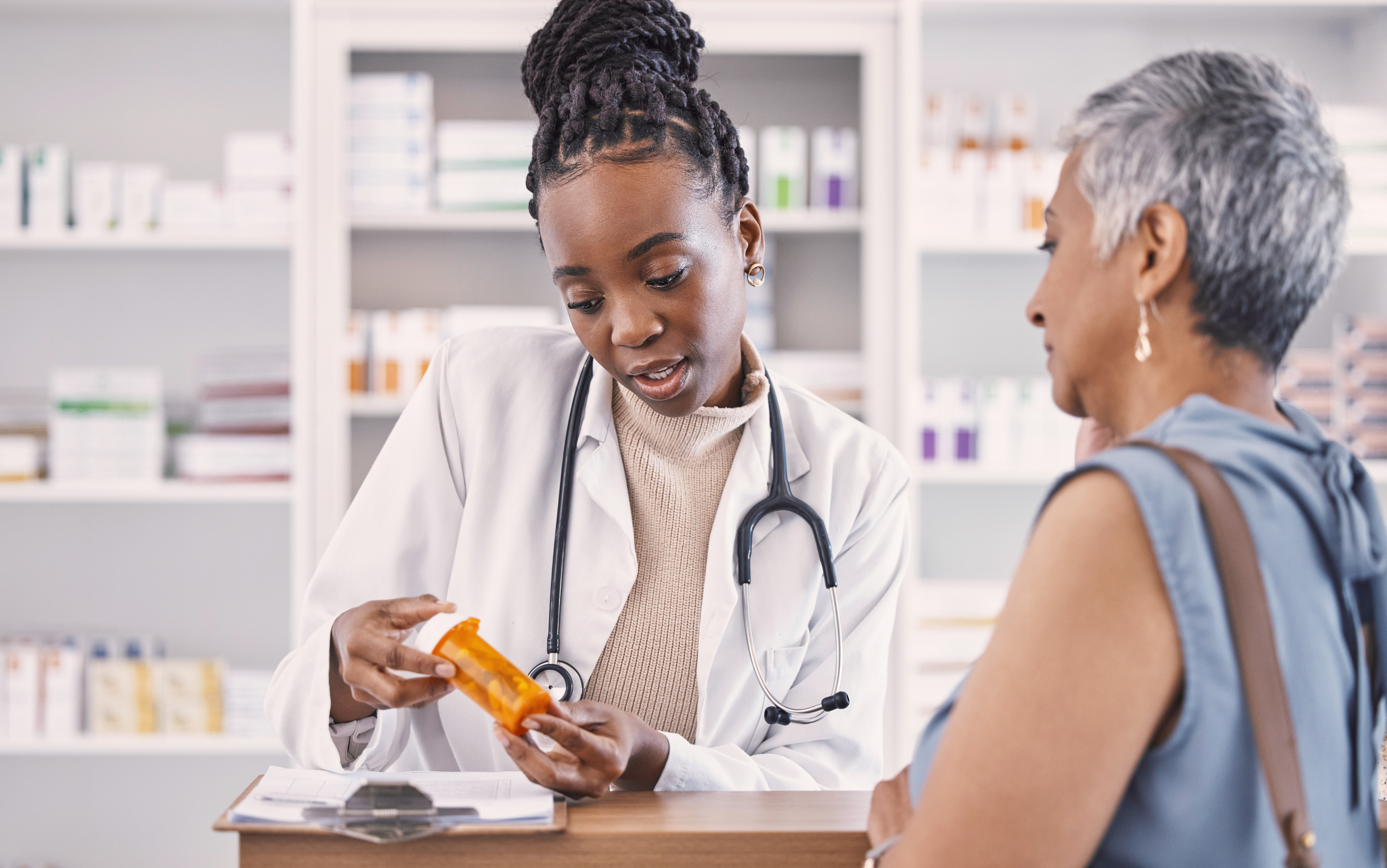 Pharmacist with pill and patient