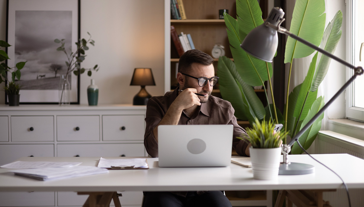 man sitting at desk on laptop