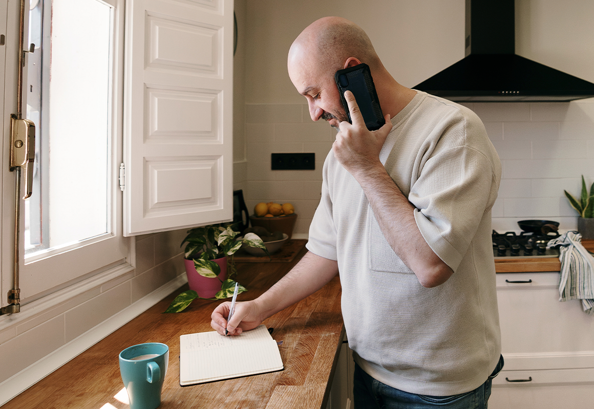 Man on phone taking notes