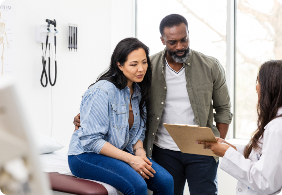 couple speaking to the doctor in an exam room