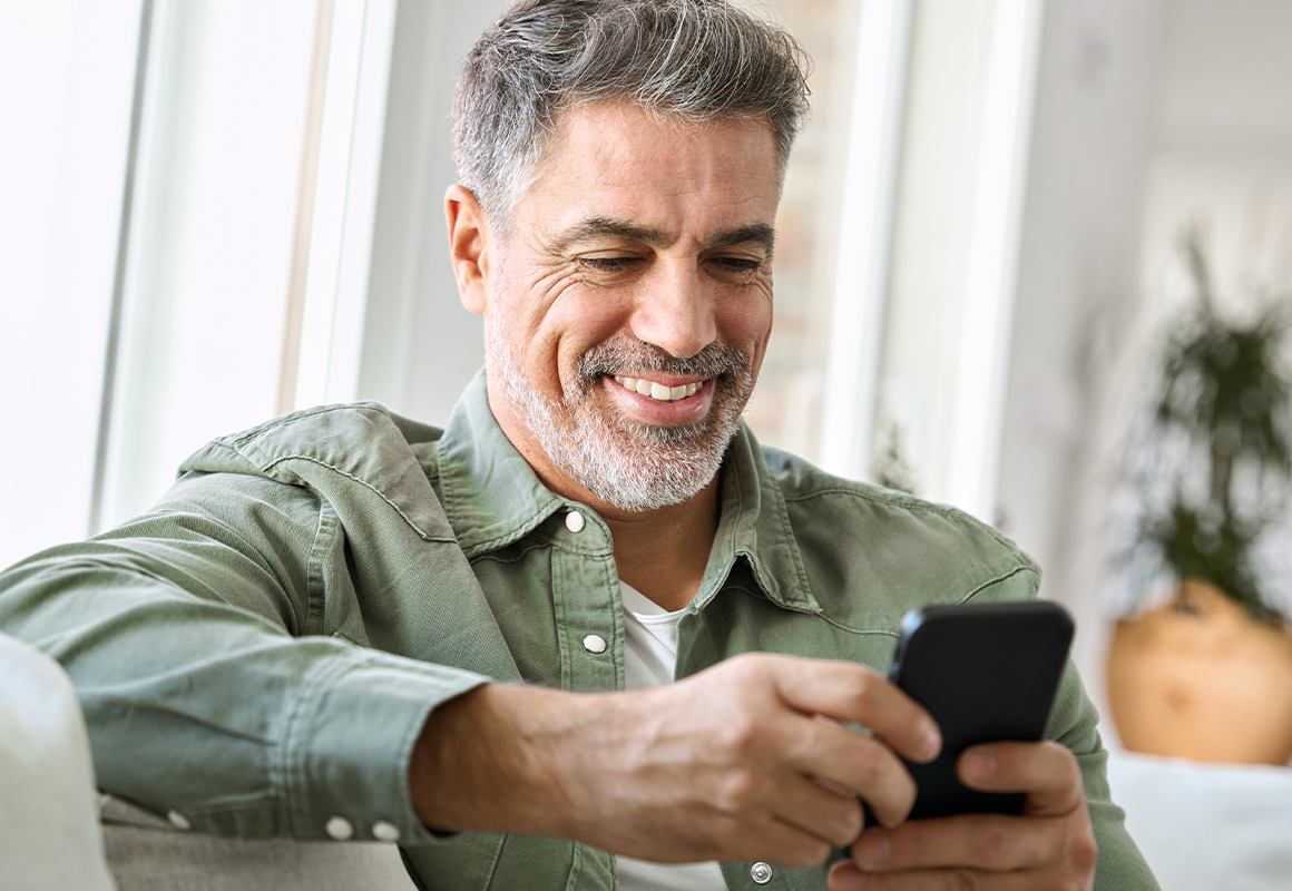 man smiling at cell phone