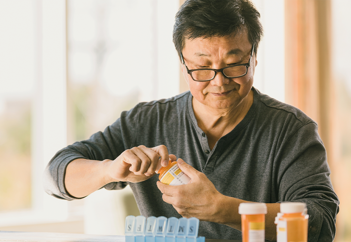 man filling pill container