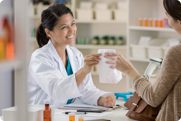 pharmacist handing a patient their prescription