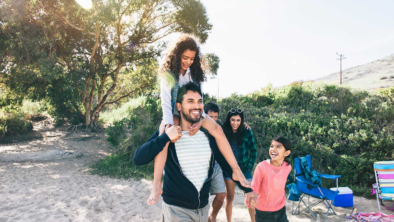 family outdoors smiling and walking together