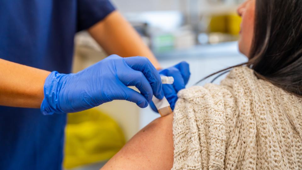 a person injecting a person's arm