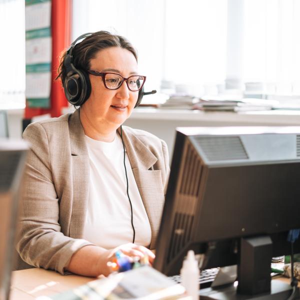 Woman working on laptop and talking on phone
