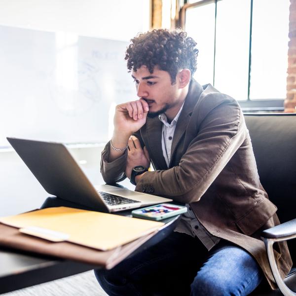 male young employee looking at laptop