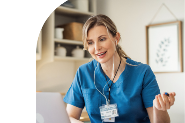 health care professional at her desk, speaking to someone on a virtual meeting