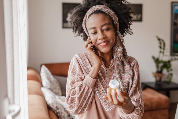 patient on phone with pill bottle
