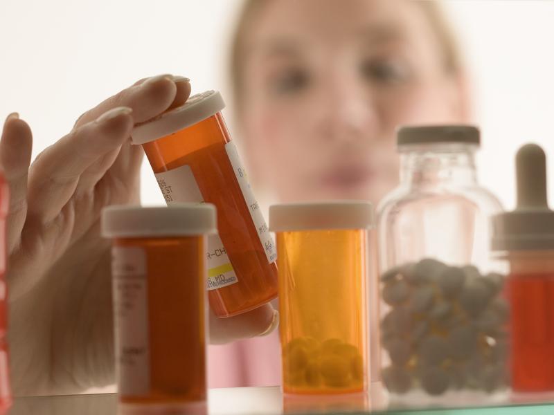 Woman gazing into a crowded medicine cabinet