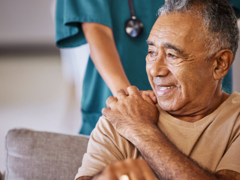 elderly gentleman being comforted by a health care provider